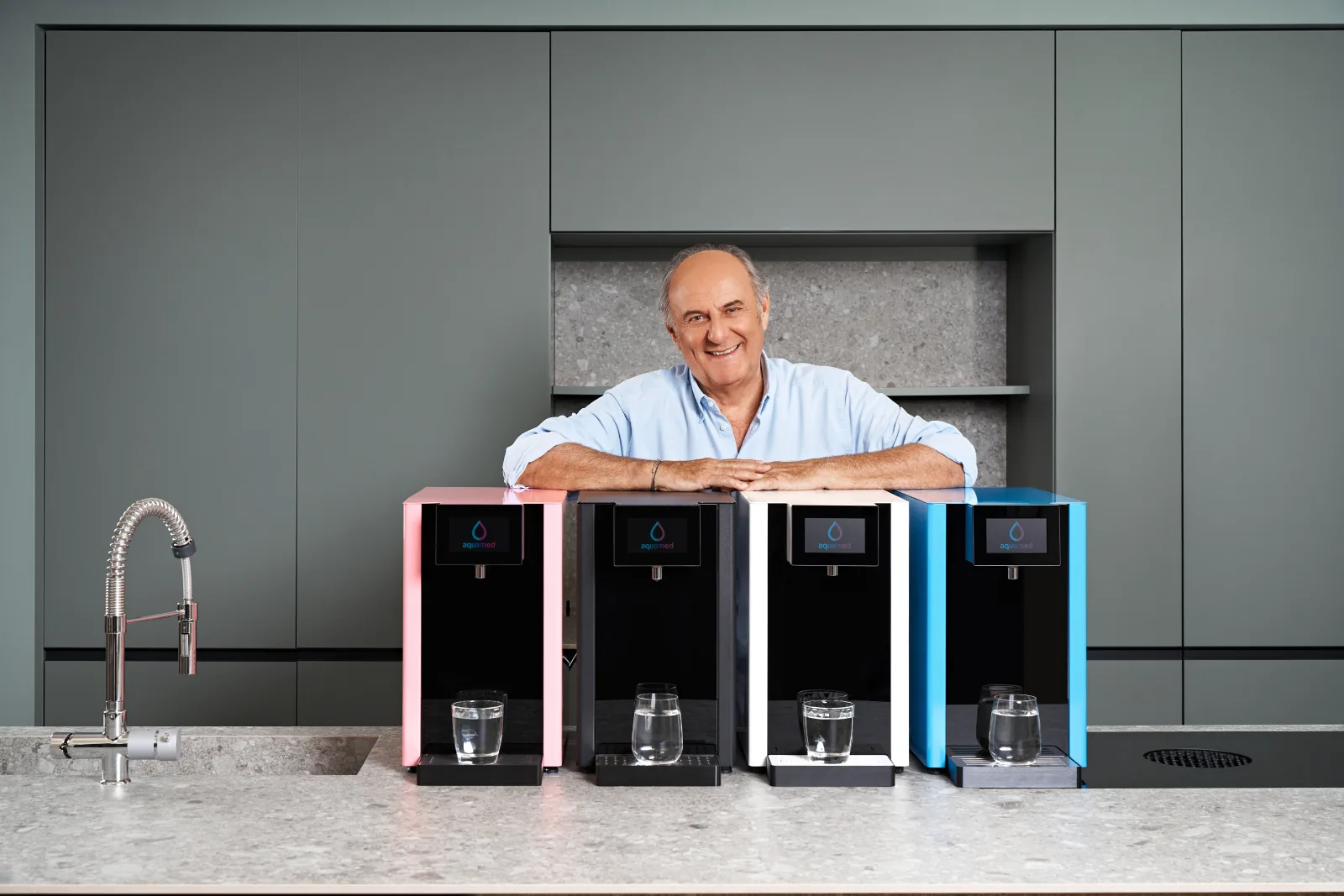 Gerry Scotti in cucina con quattro dispositivi Aquamed Gassy Top nei diversi colori